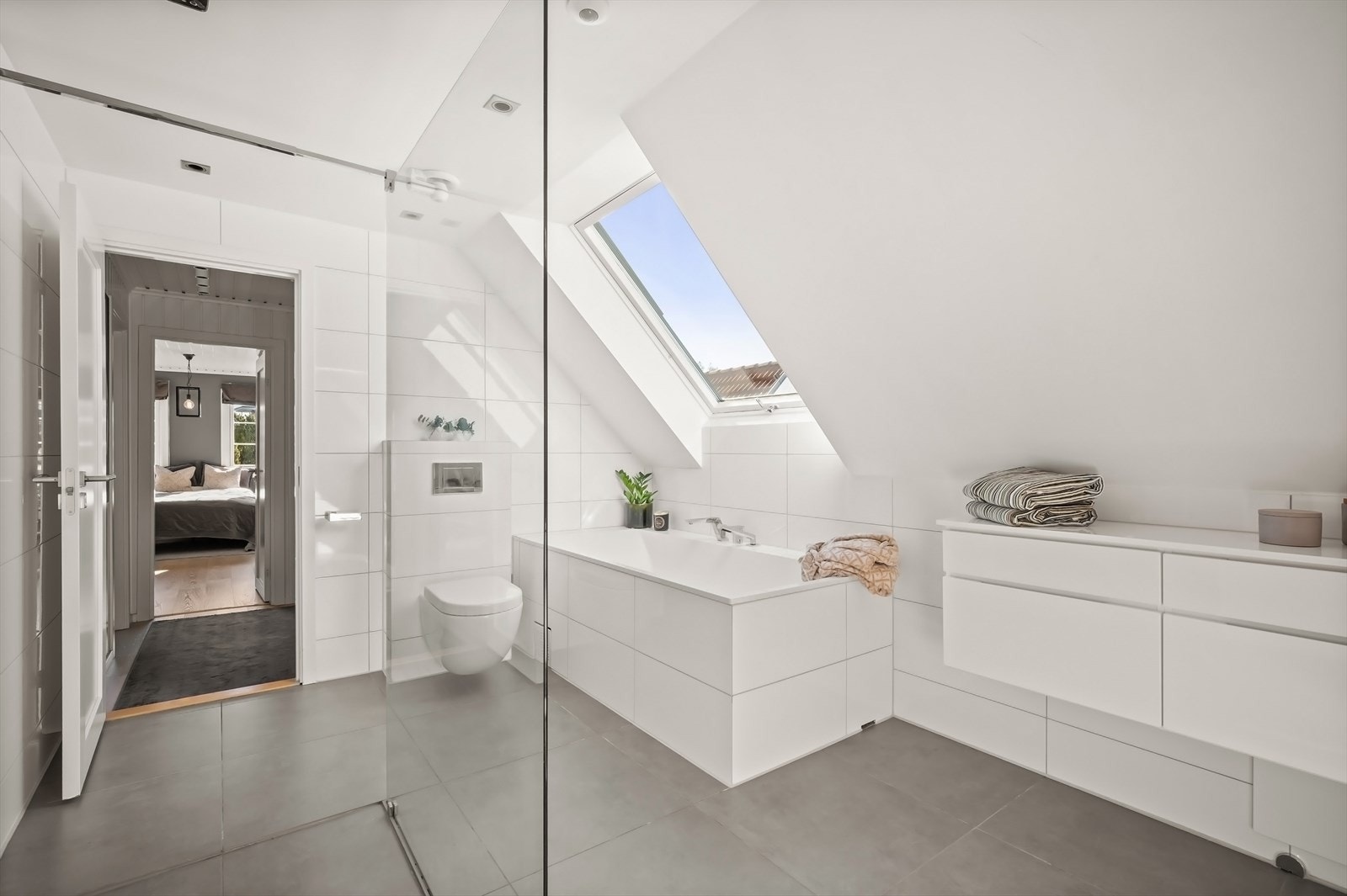 Stor og lyst bad. Downlights i himling og store fliser. Se himmelen fra badekaret. Galleribilde