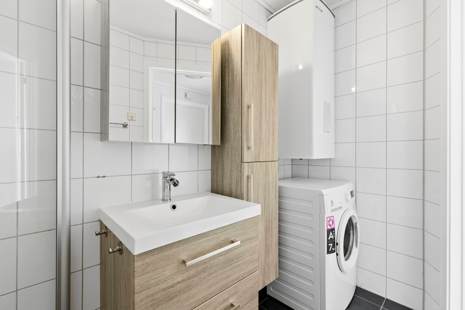 Videre har badet dusjhjørne med dører i herdet glass, samt et frittstående toalett. Opplegg for vaskemaskin i egen nisje. Galleribilde