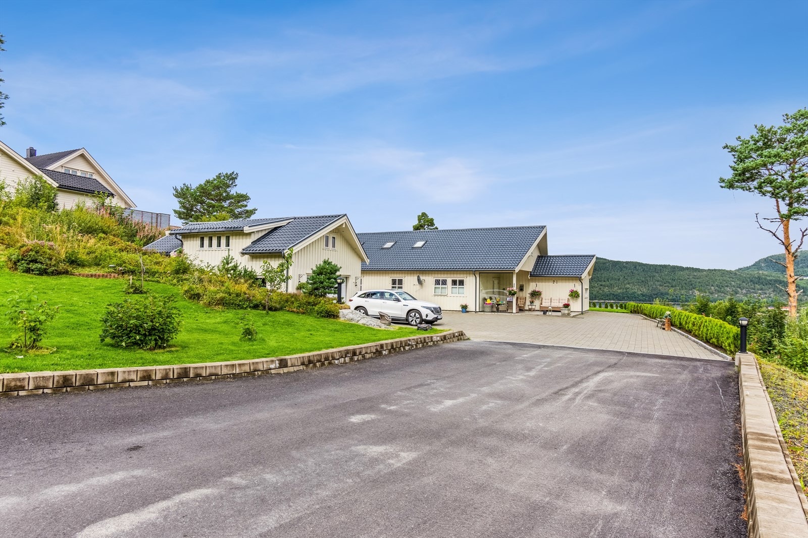 Asfaltert innkjørsel og stenbelagt gårdsplass med plass til cirka 6-7 biler, samt én garasjeplass. Galleribilde