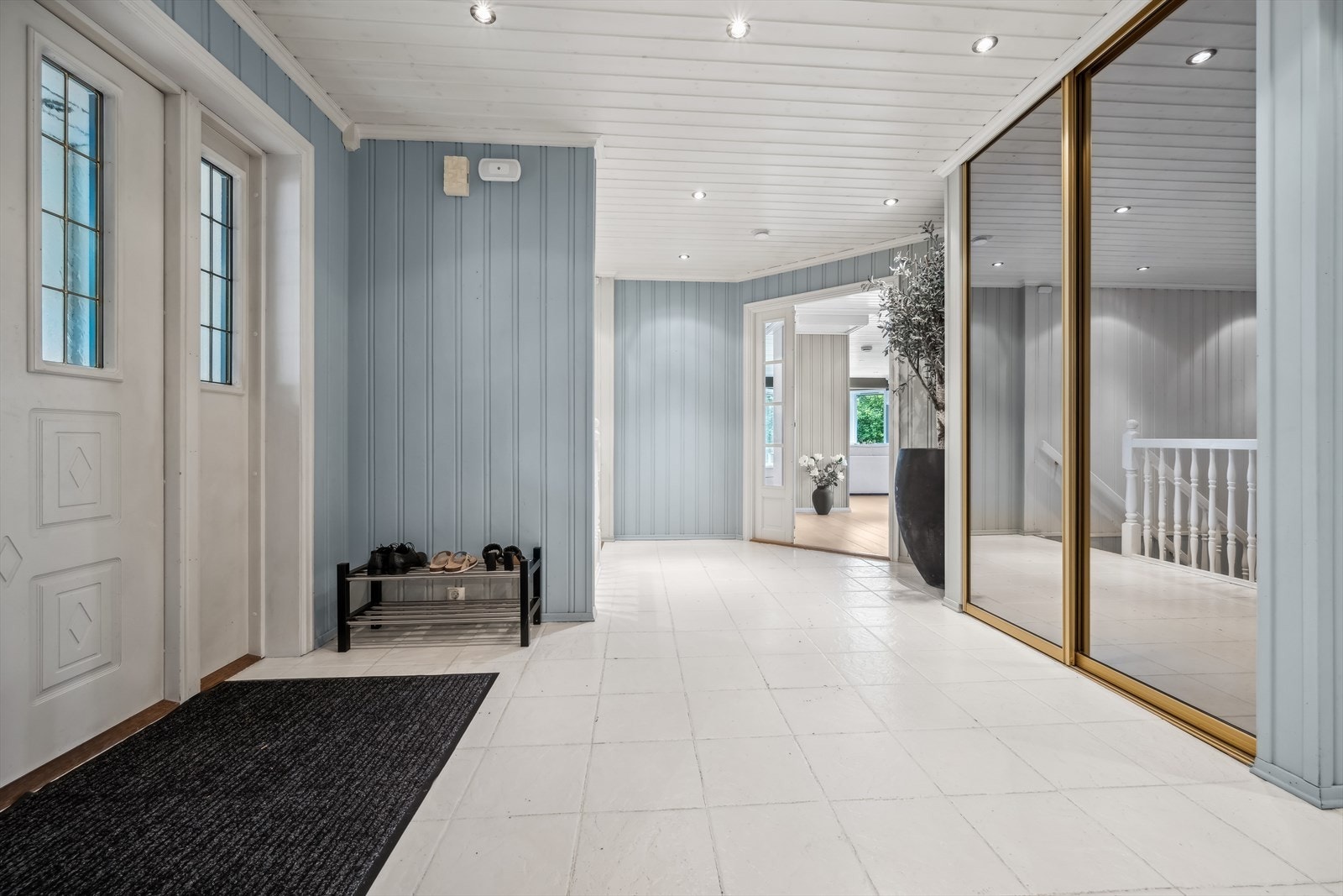 Vel innenfor ytterdøren venter en lys hall med flislagt gulv og downlights i himling. Galleribilde