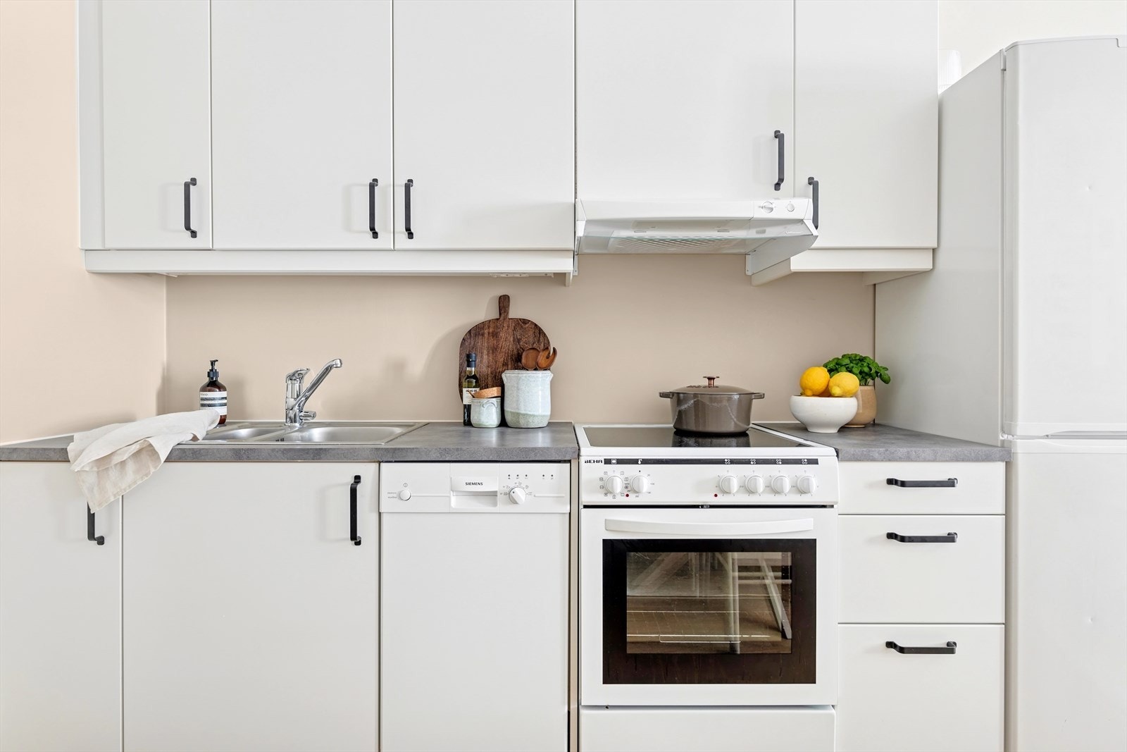 Lekker kjøkkeninnredning fra Norema med slette fronter, benkeplate i laminat og nedfelt oppvaskkum med ett-greps blandebatteri Galleribilde