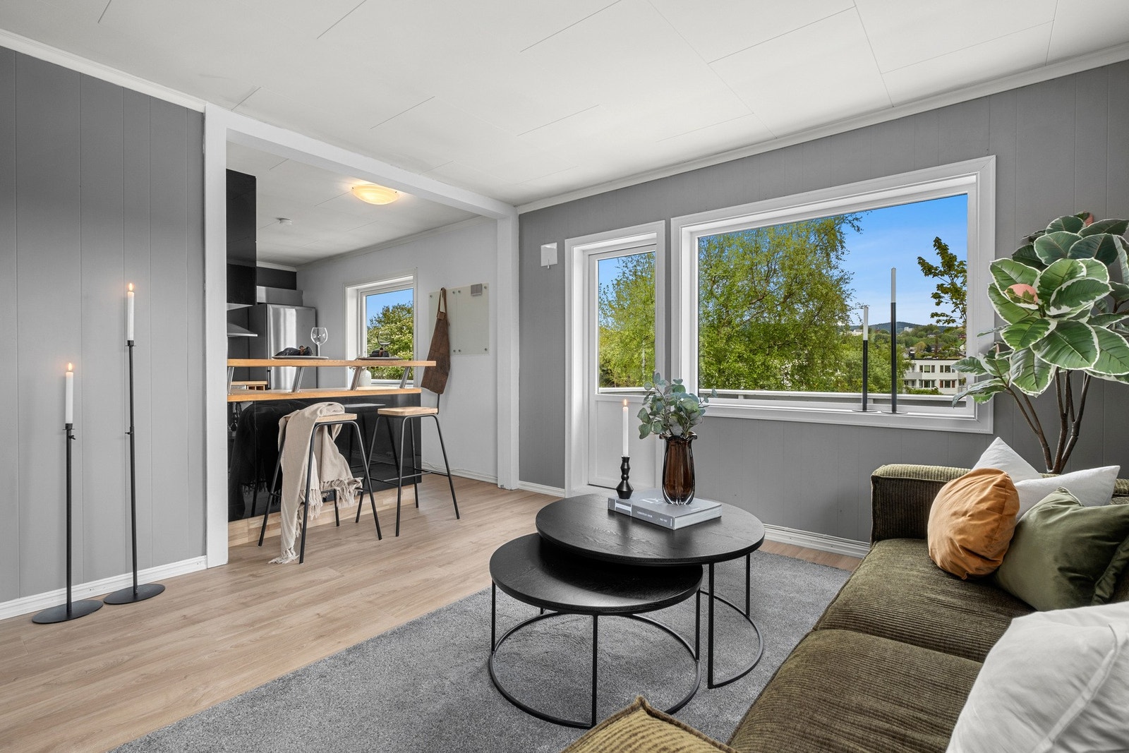 Leiligheten har store vindusflater som sikrer godt med naturlig dagslys inn til stuen Galleribilde