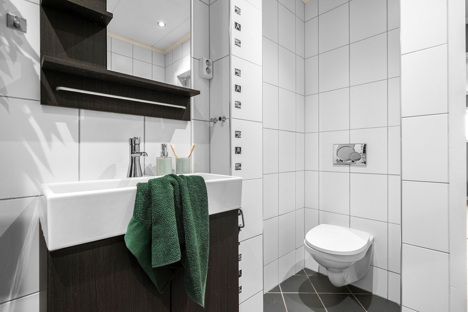 Badet er utstyrt med dusjkabinett, vegghengt toalett og downlights i taket Galleribilde