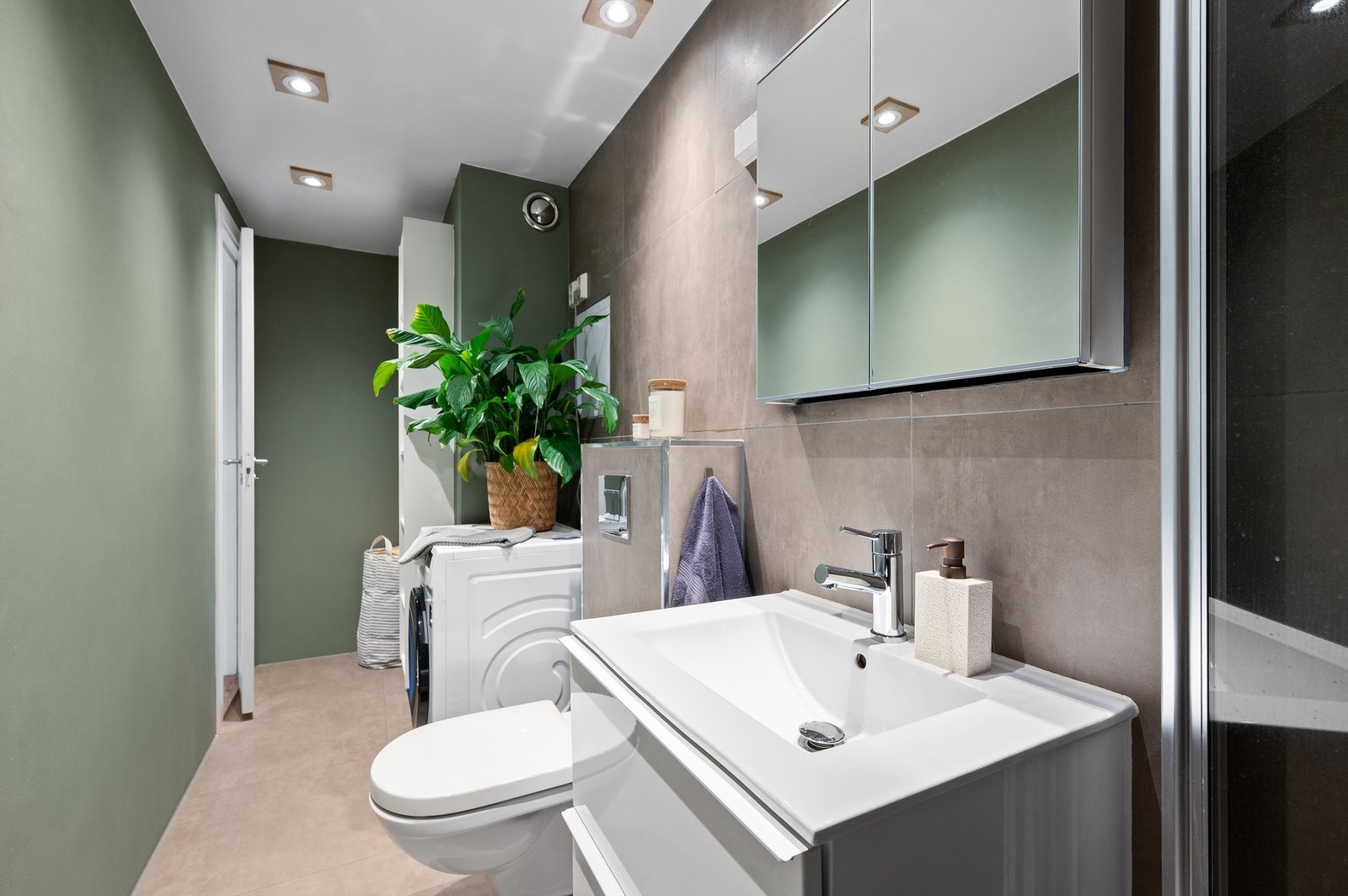 Flislagte vegger og gulv skaper et stilrent uttrykk, mens elektrisk gulvvarme sørger for god komfort året rundt Galleribilde