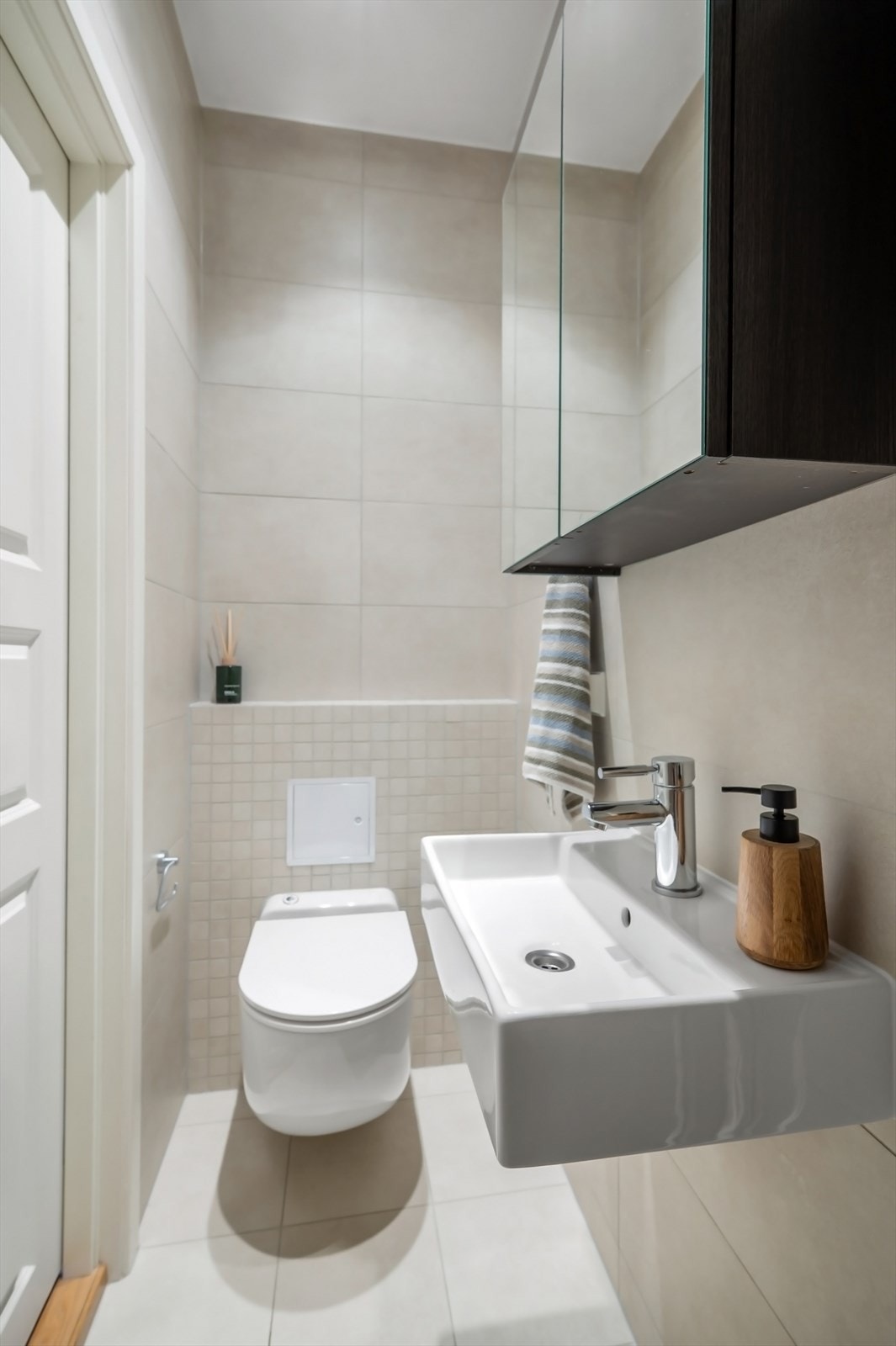 Utstyrt med veggmontert toalett, servant, speilskap og dusj. Galleribilde