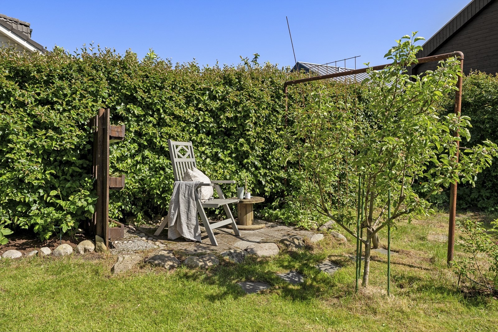 - Det er laget til en hyggelig uteplass i hagen hvor man kan nyte kveldssolen - Galleribilde