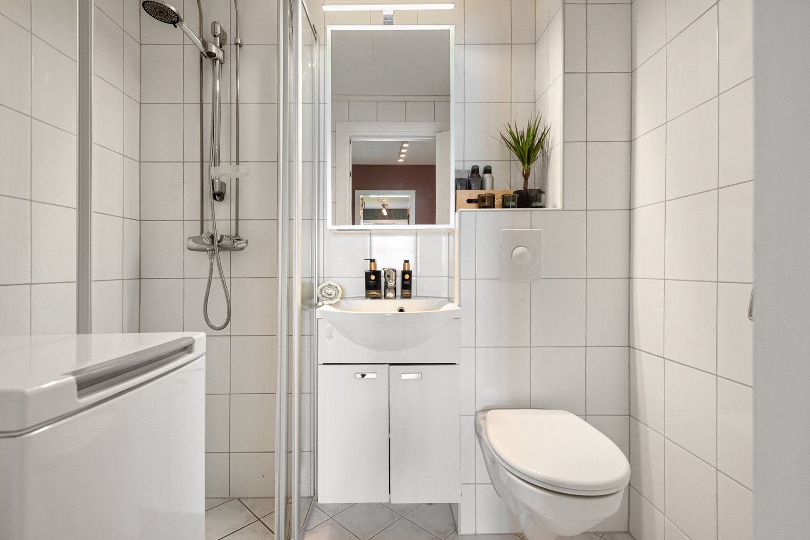 Badet fremstår som lyst og innbydende, med lyse fliser på både gulv og vegger som gir rommet et rent og moderne uttrykk. Galleribilde