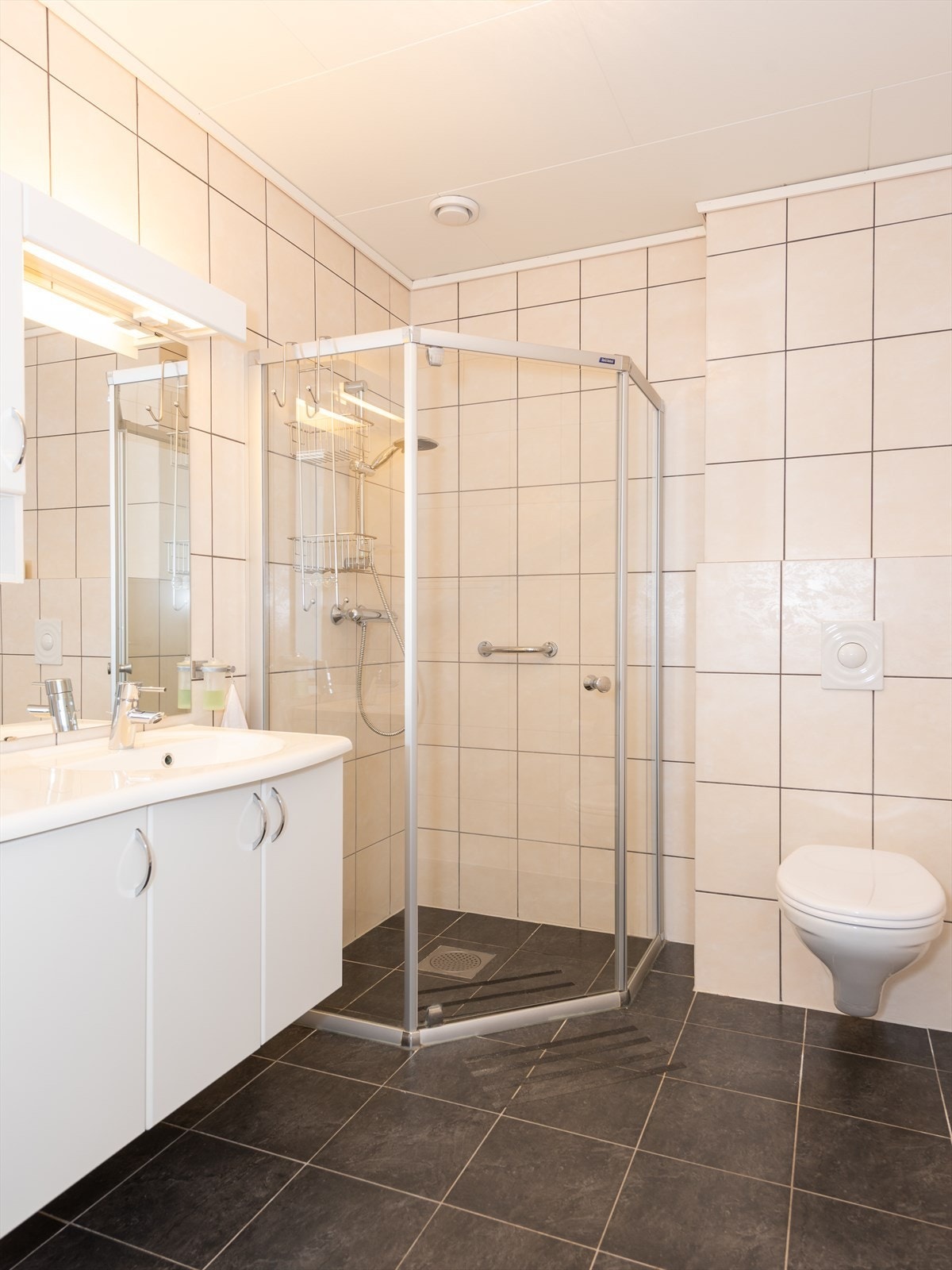Her er det flislagt gulv og vegger. Badet har elektrisk gulvvarme for ekstra komfort. Galleribilde