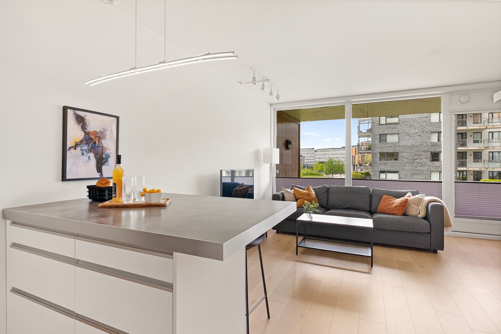 Romslig og pen stue med heltre gulv og store vindusflater Galleribilde