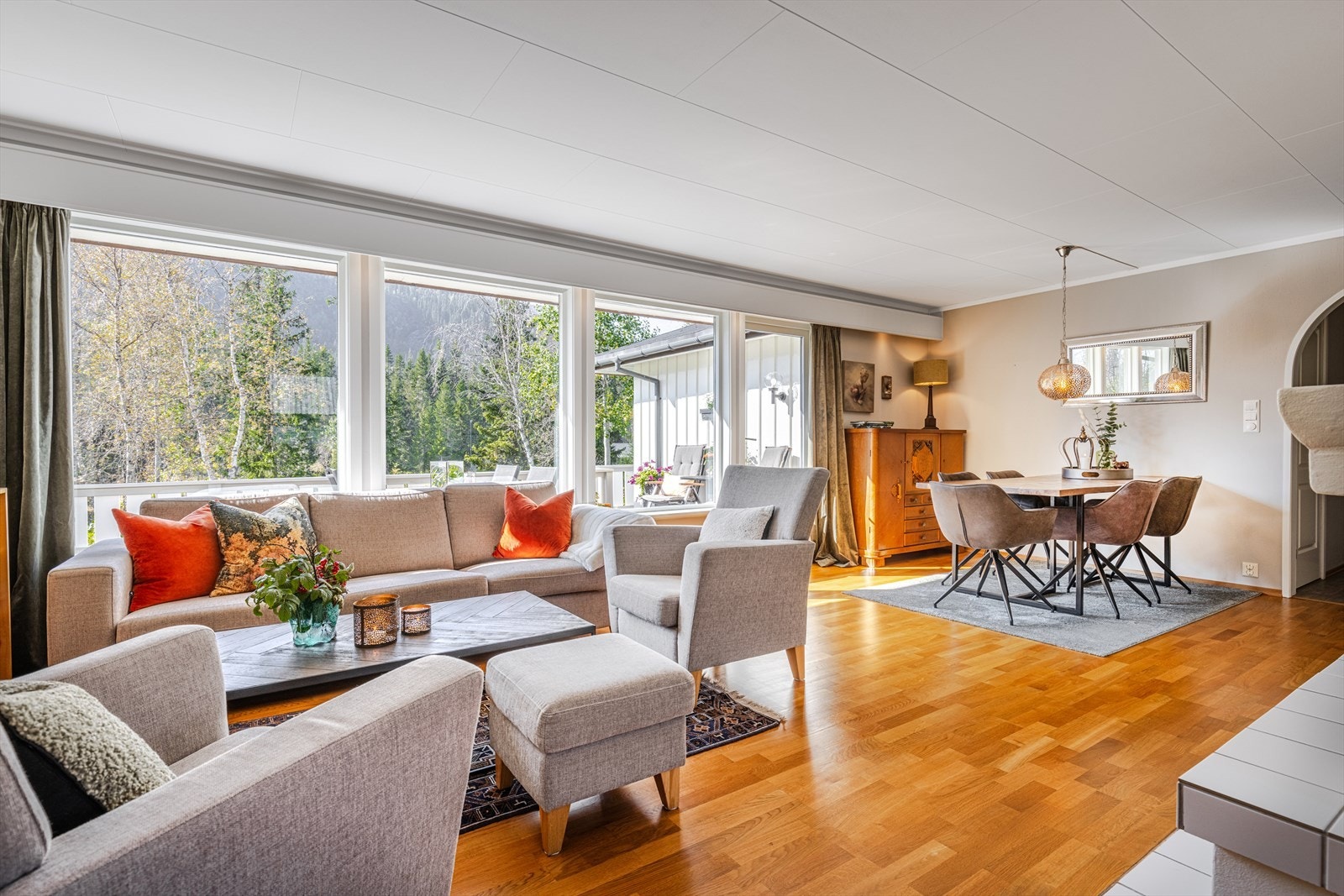 Store vindusflater som skaper godt med naturlig lys inn i oppholdsrommet og åpner mot privat og hyggelig utsikt. Galleribilde