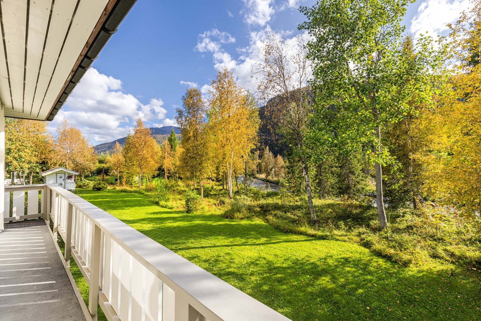 Fra terrassen er det trapp ned til hagen. Vinterstid skimtes Hemsedal skisenter bak lauvtrærne! Galleribilde
