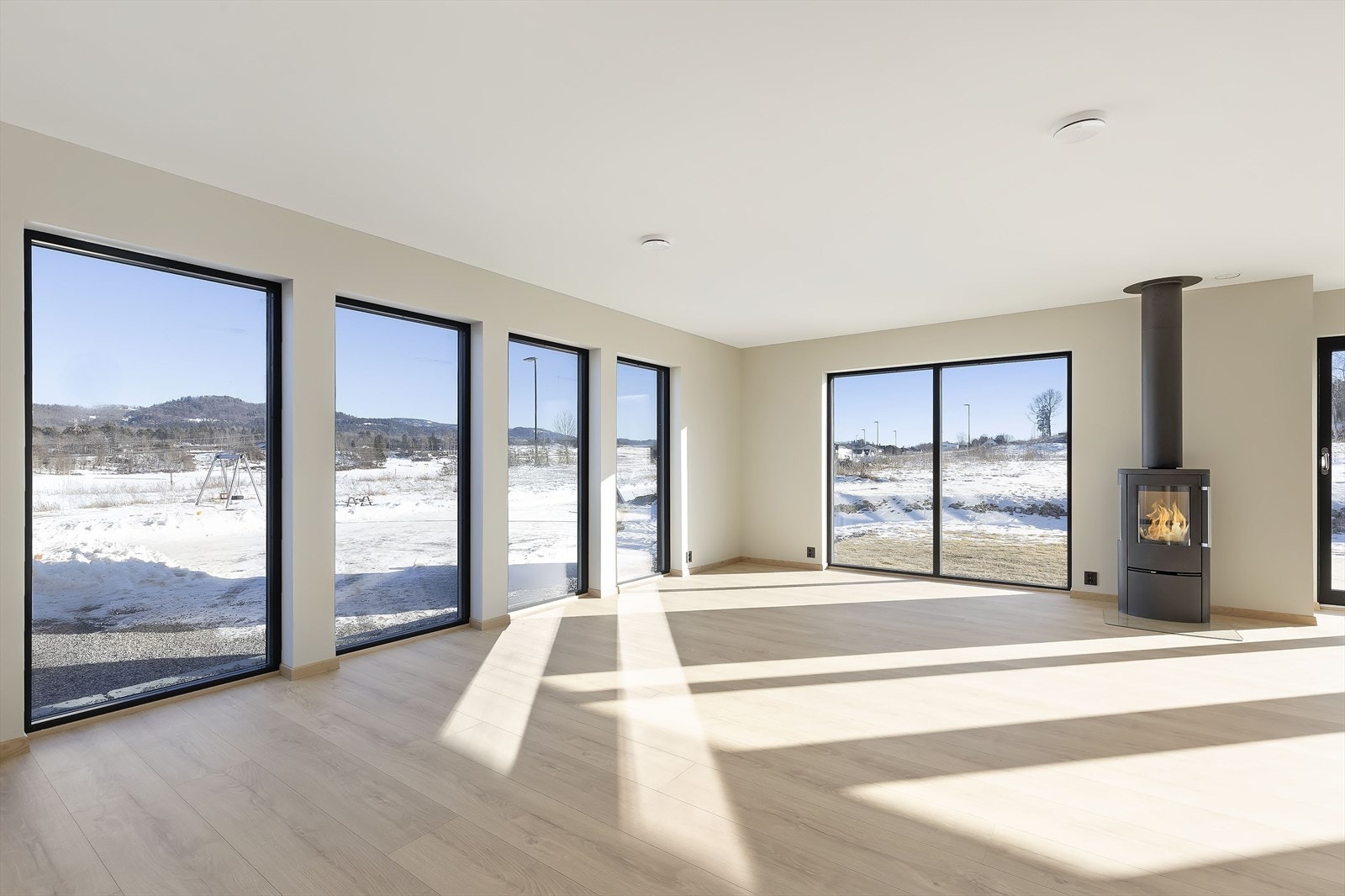 Stue og kjøkken i 1. etasje har store vindusflater med fint utsyn - her mot lekeplassen på området Galleribilde