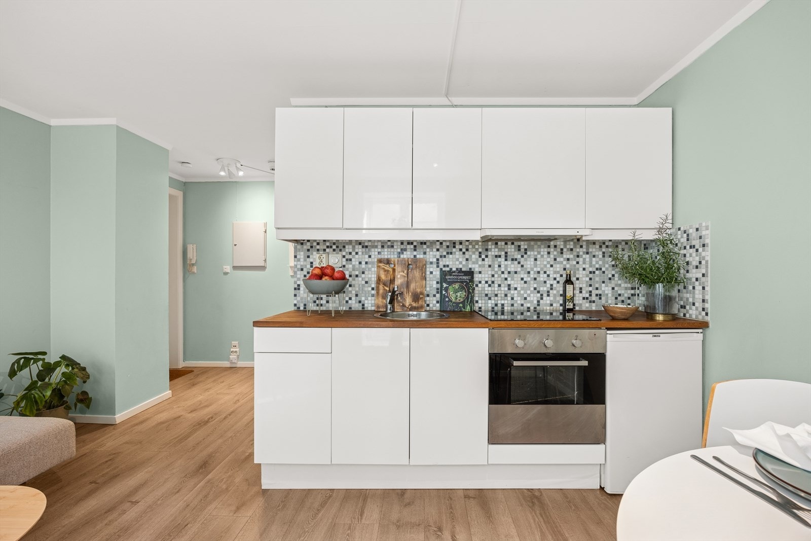 Kjøkkeninnredningen har glatte fronter og en heltre benkeplate som gir et elegant uttrykk. Galleribilde