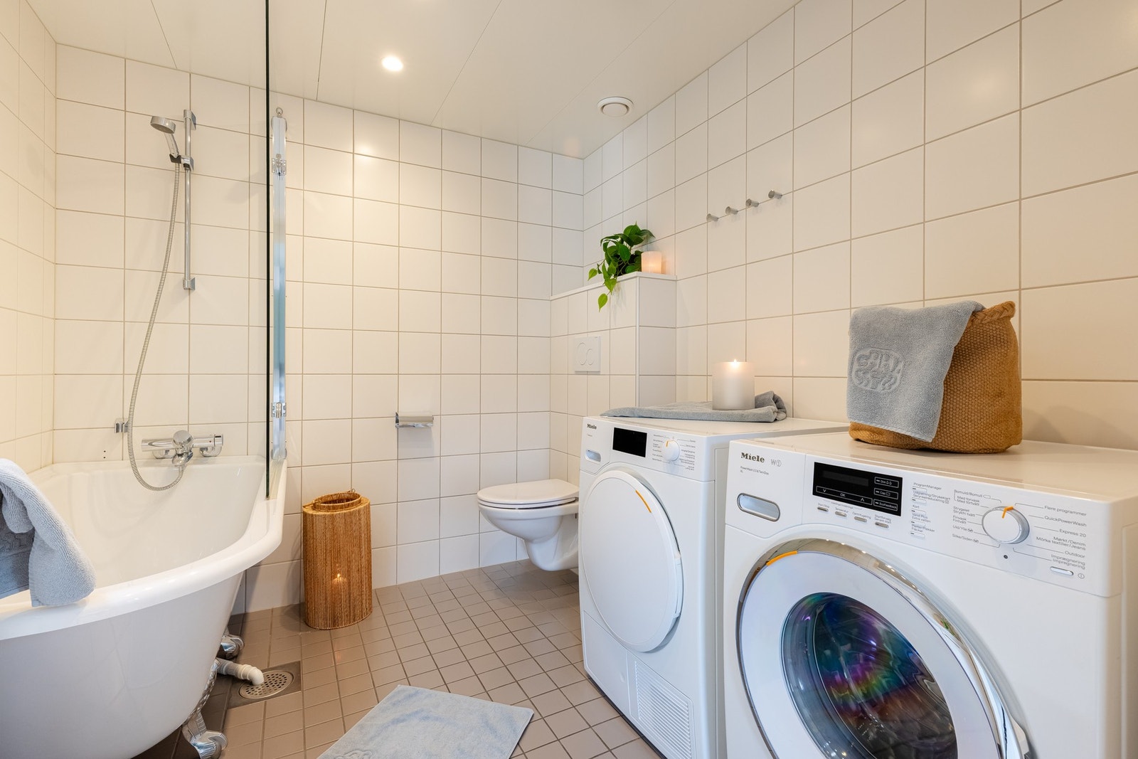 Det er delikate fliser både både på gulv og vegger. På badet er det innredning med tre skap og servant, badekar og vegghengt toalett. Galleribilde