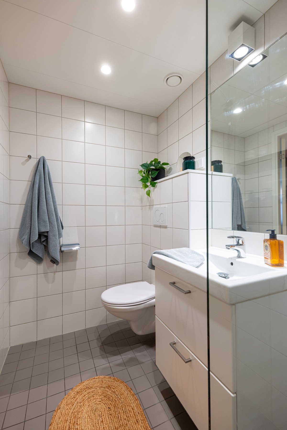 Badet er utstyrt med innredning med to skuffer og servant, dusj med glassdører og vegghengt toalett. Galleribilde