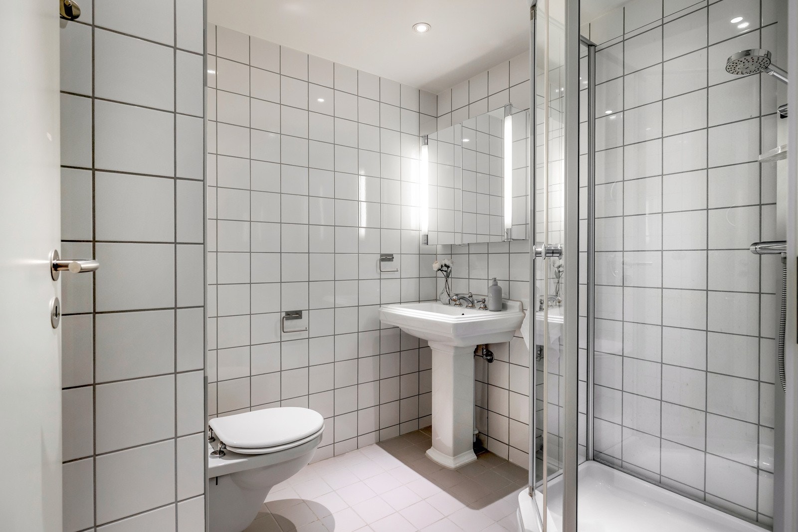 Badet er utstyrt med toalett, dusjkabinett og servant Galleribilde