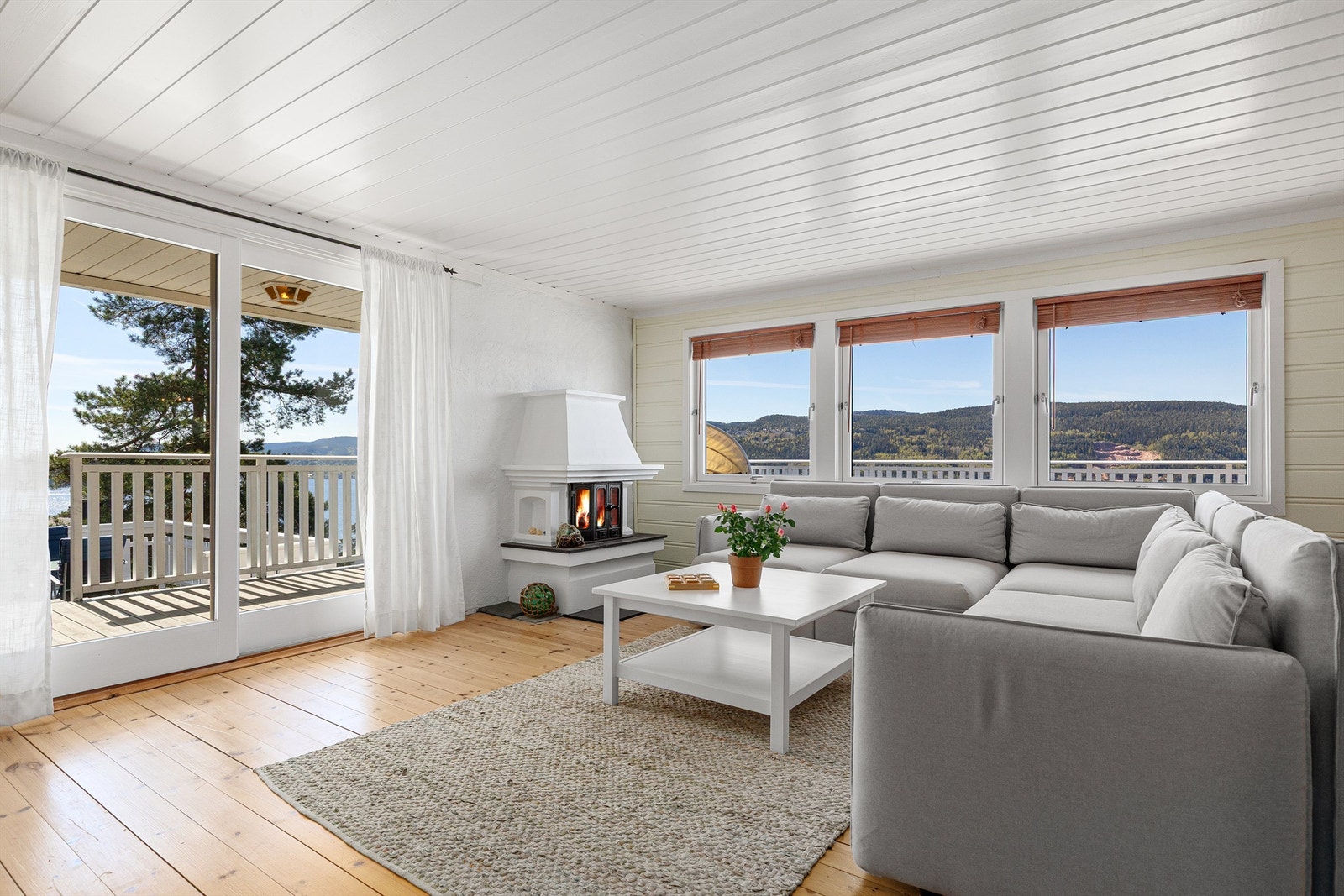 Hytta er malt opp i lyse og sommerlige farger. Fra stuen er det utgang til terrasse Galleribilde