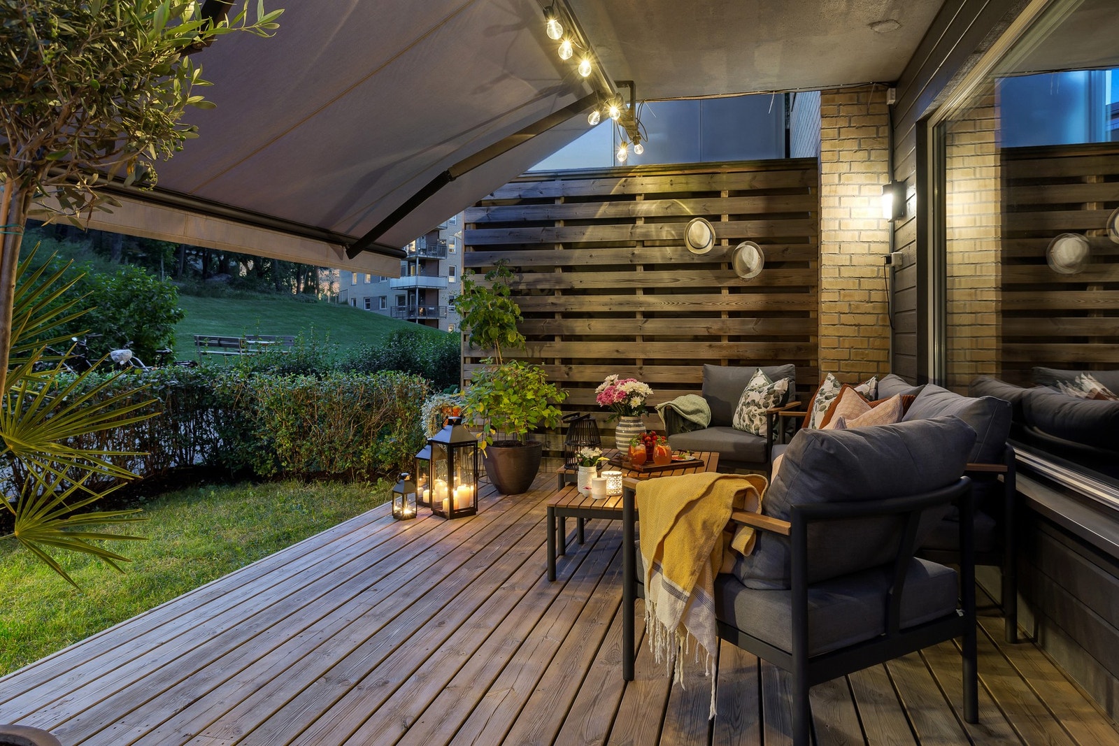 Kveldsstemning på terrassen. Stor markise skjermer på de varmeste dagene og gir bruksmulighet på terrassen ved ruskevær. Galleribilde