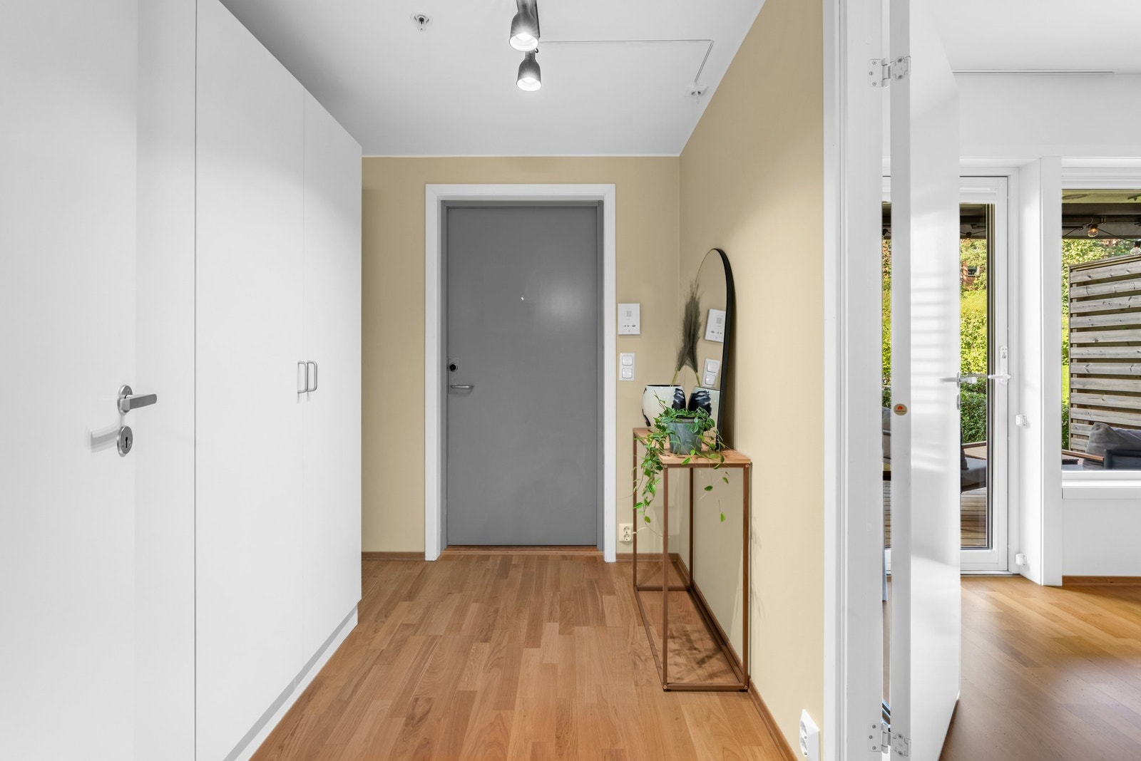 Her ønskes du velkommen inn i en rosmlig entrè med garderobeskap, trestavs eikeparkett, og vegger malt opp i en pen gulfarge i 2022. Galleribilde