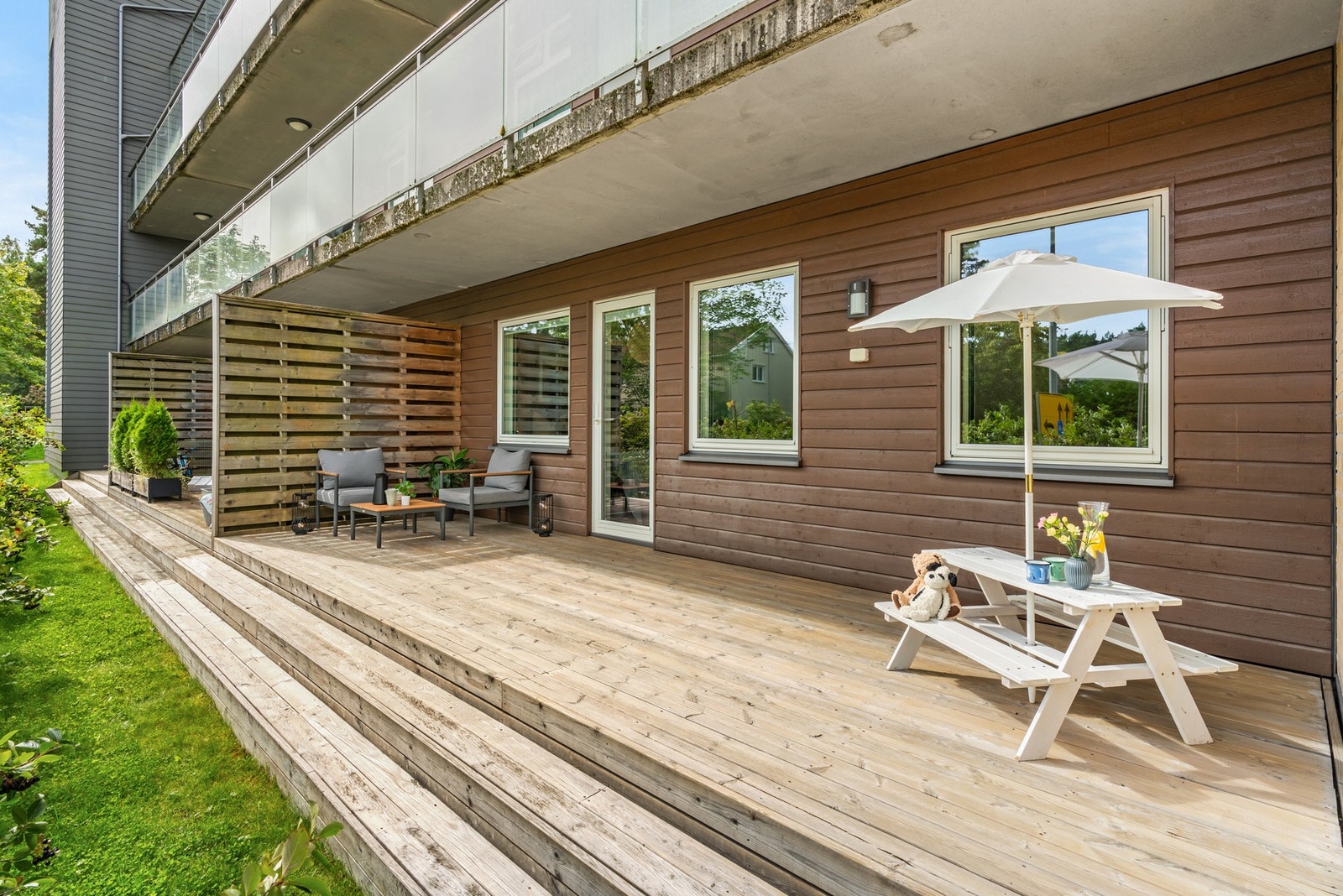 Terrassen er tilbaketrukket med grønne omgivelser og hekk som skjermer mot nabolaget. Galleribilde