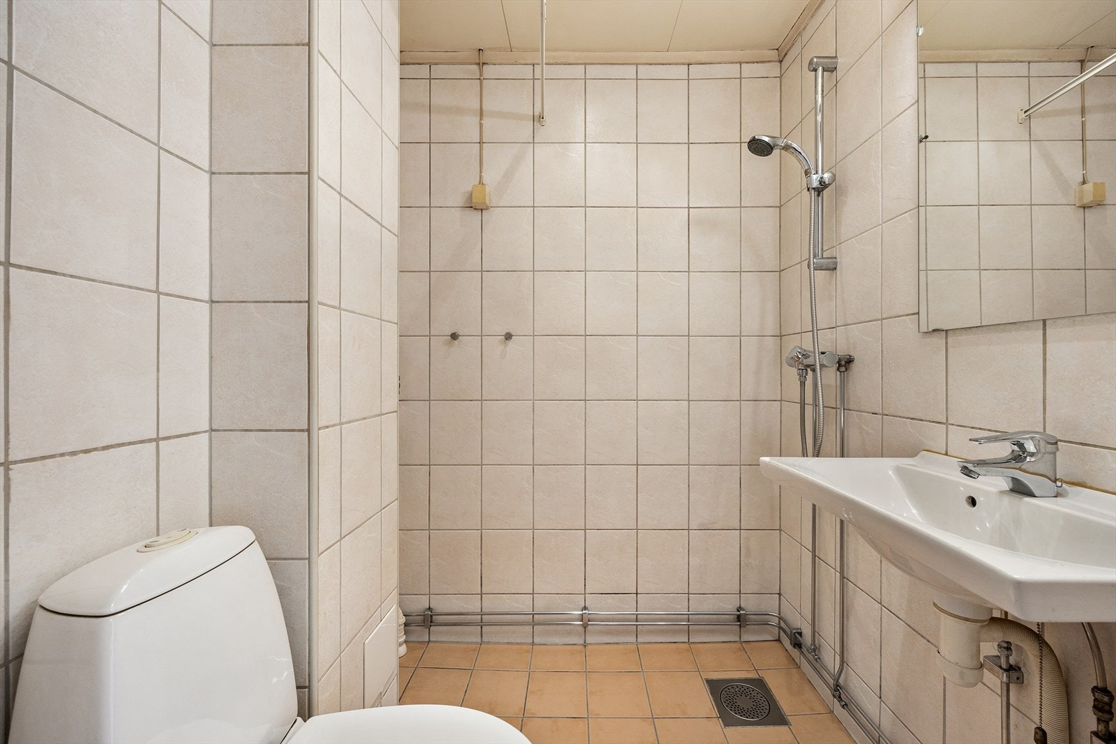 Flislagt baderom med varmekabler og opplegg for vaskemaskin Galleribilde