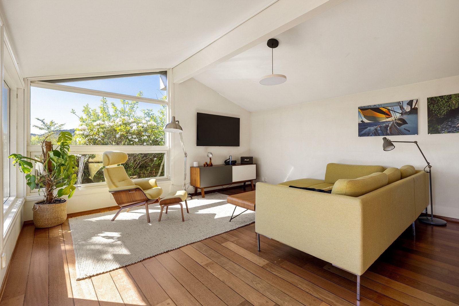 Rommets åpne utforming og naturlige lys gjør det enkelt å møblere både med sofagruppe og spisebord - her er det plass til både familiehygge og gjestemiddager. Galleribilde