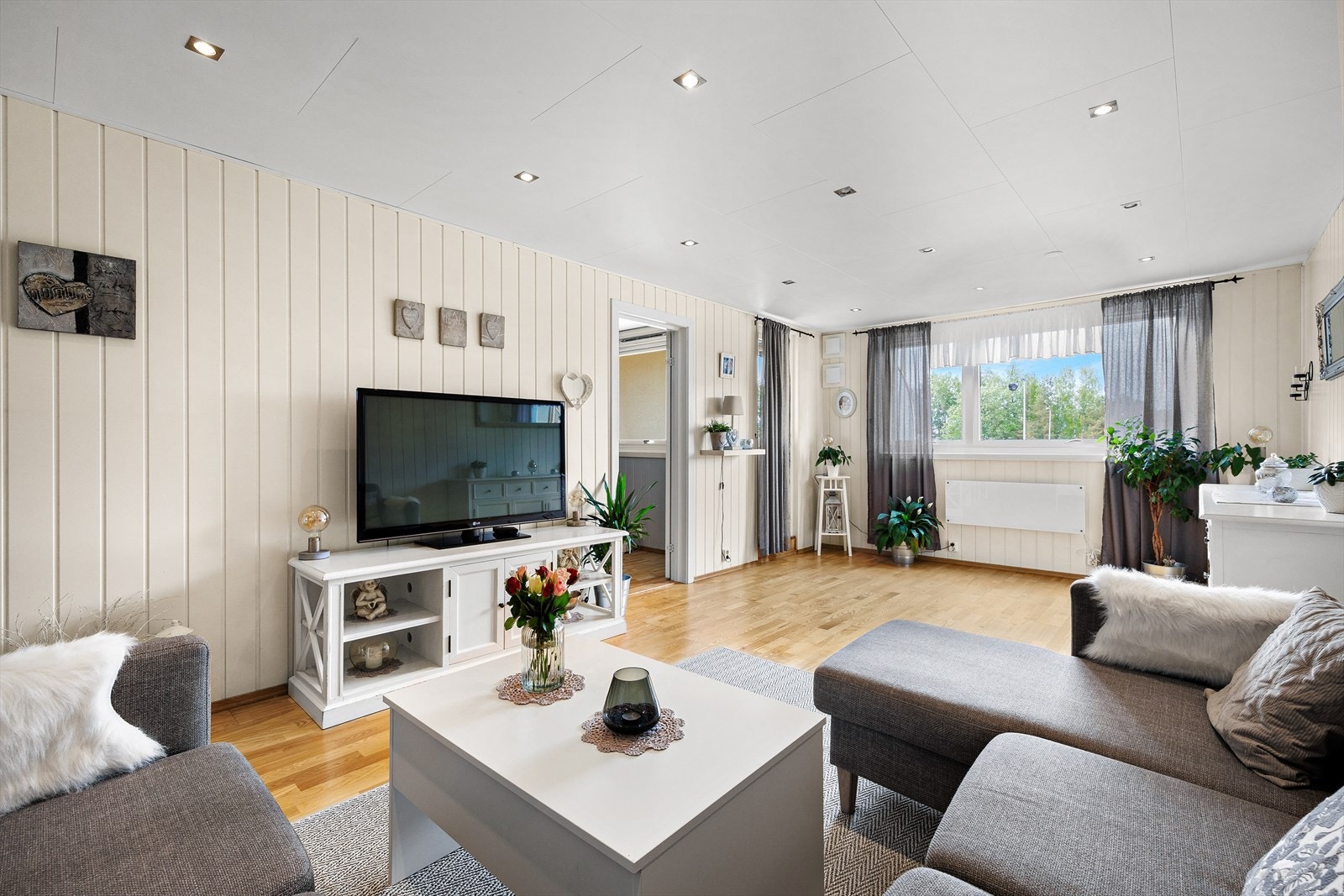 Stuen har store vinduer som slipper inn rikelig med naturlig lys Galleribilde