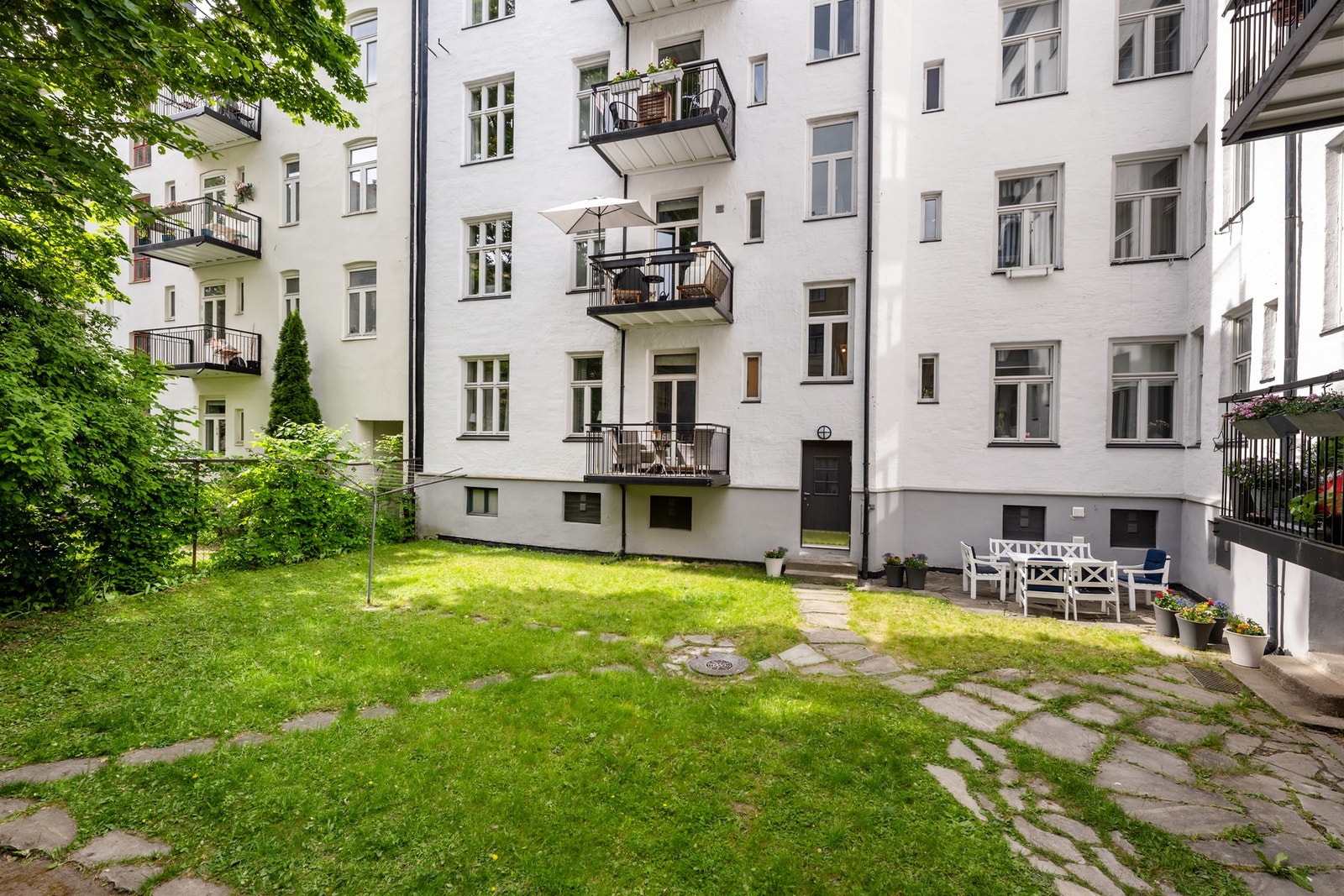 Koselig bakgård, opparbeidet med gressplen og beplantet med lønnetre Galleribilde