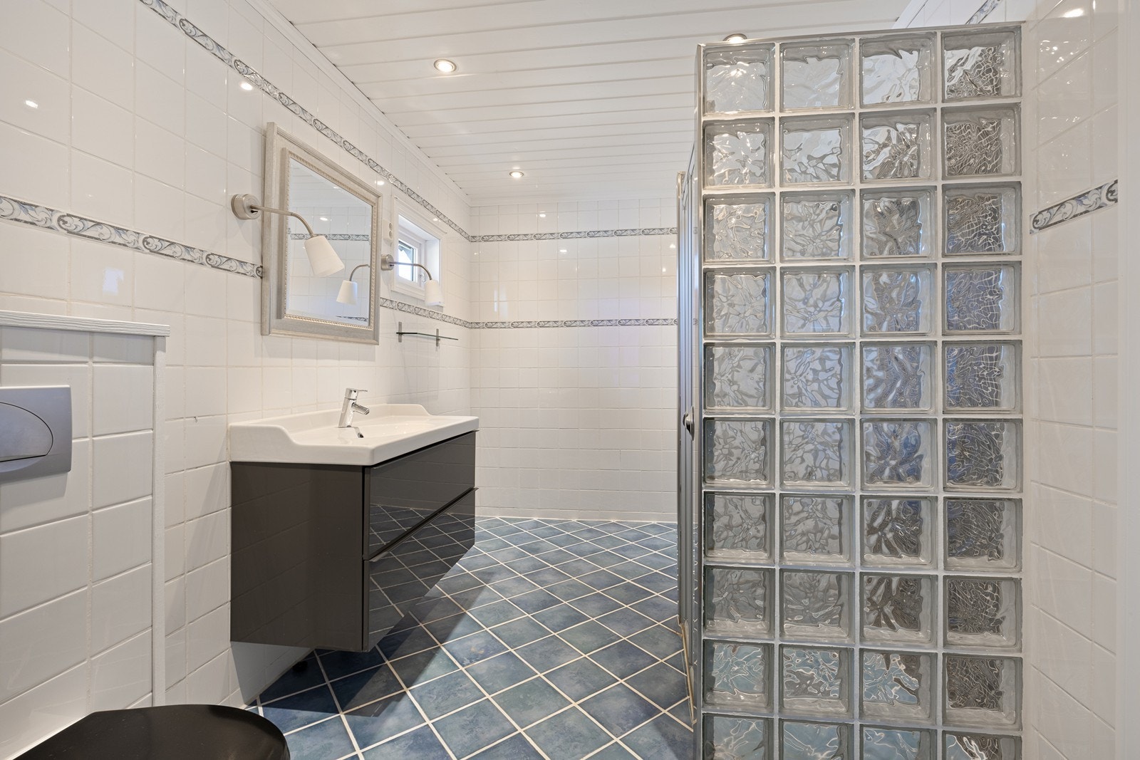 Badet ligger i første etasje og er fra 2005, helfliset med varmekabler i gulvet og downlights i taket. Galleribilde