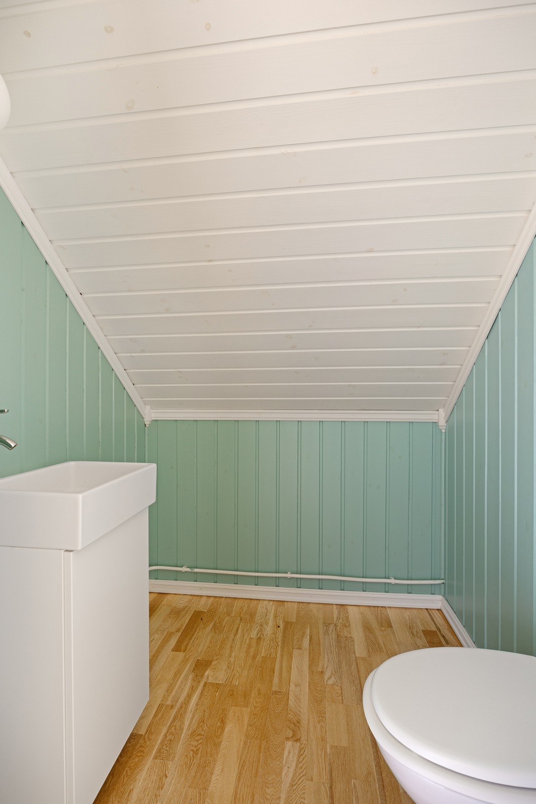 Toalettrommet oppe er innredet med veggmontert toalett og en hvit servantinnredning. Galleribilde