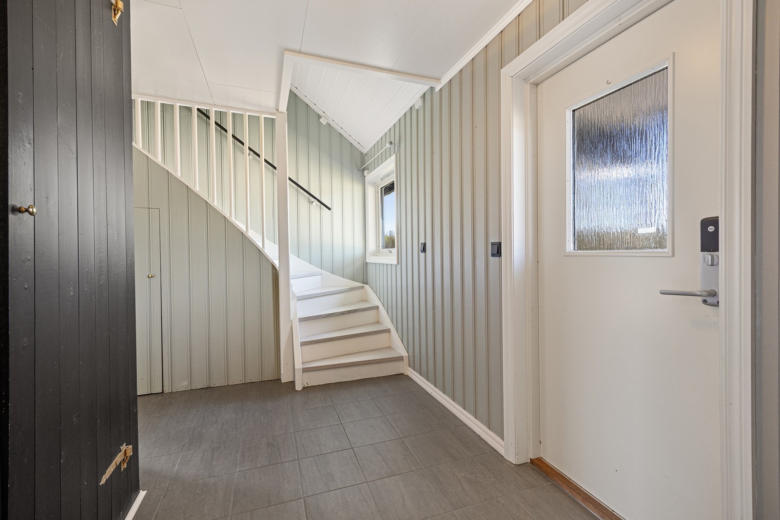 Fra entreen fører en hvitmalt trapp opp til loftet, som ble innredet med tre soverom, garderoberom og toalett i 2023. Galleribilde