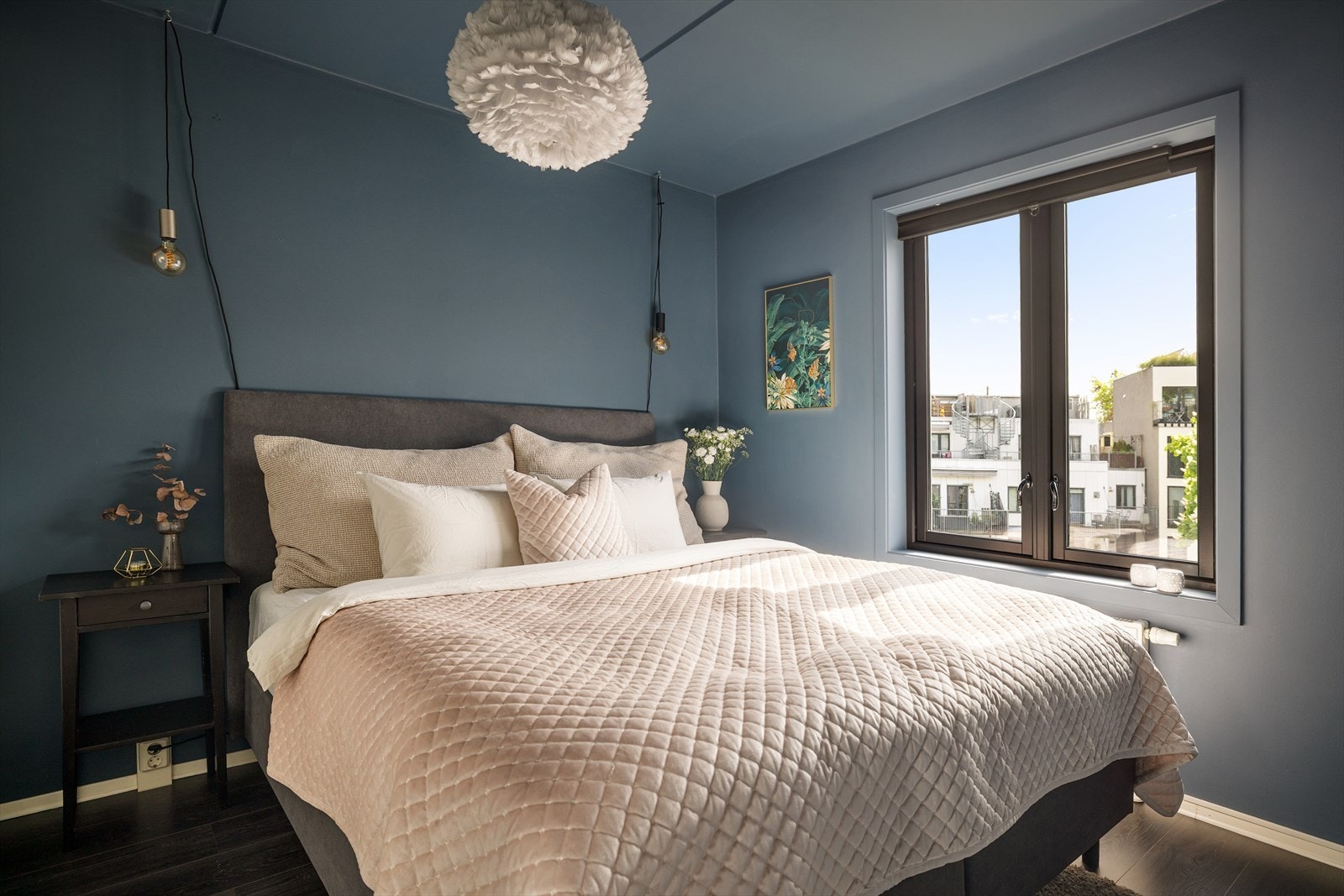 Leiligheten har et lunt og innbydende soverom malt i en behagelig blåtone. Soverommet vender ut mot en rolig bakgård. Galleribilde