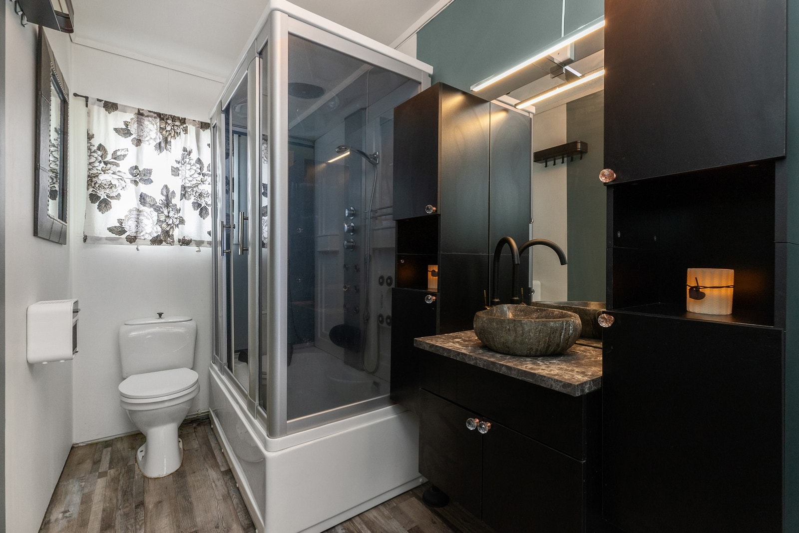 Badet i første etasjen er innredet med baderomrsinnredning, påstående steinvask, frittstående dusjkabinett og toalett. Galleribilde