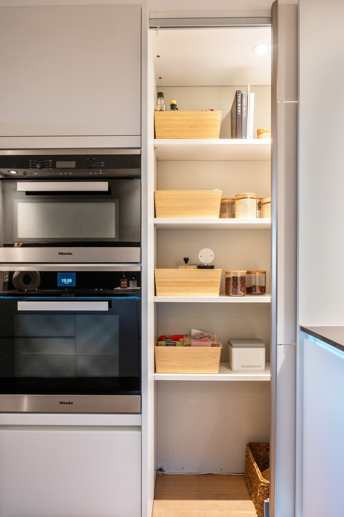 Integrert stekeovn og mikrobølgeovn fra Miele, samt praktisk kjøkkenoppbevaring med hyller og kurver. Galleribilde