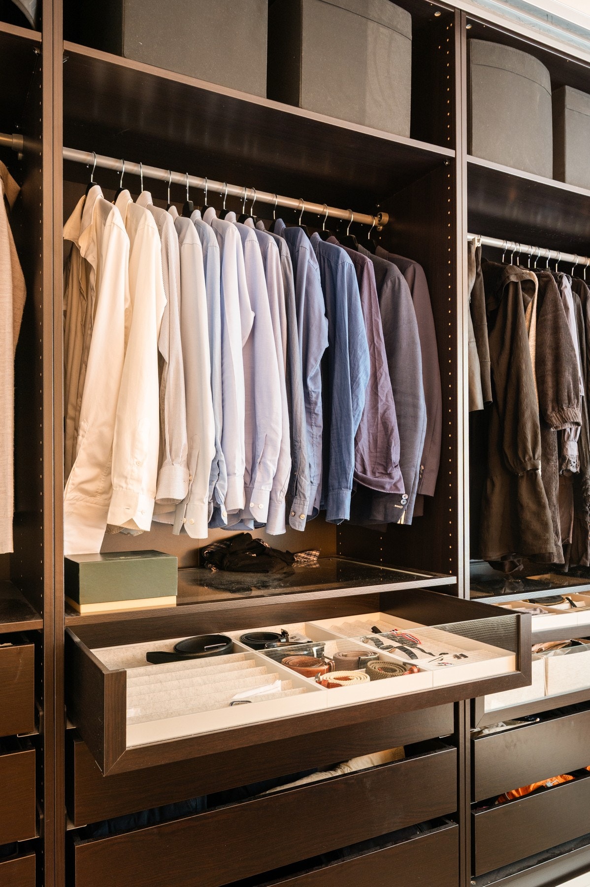 Organisert garderobe med god plass til oppbevaring med oppheng, skuffer og hyller med oppbevaringsbokser. Galleribilde