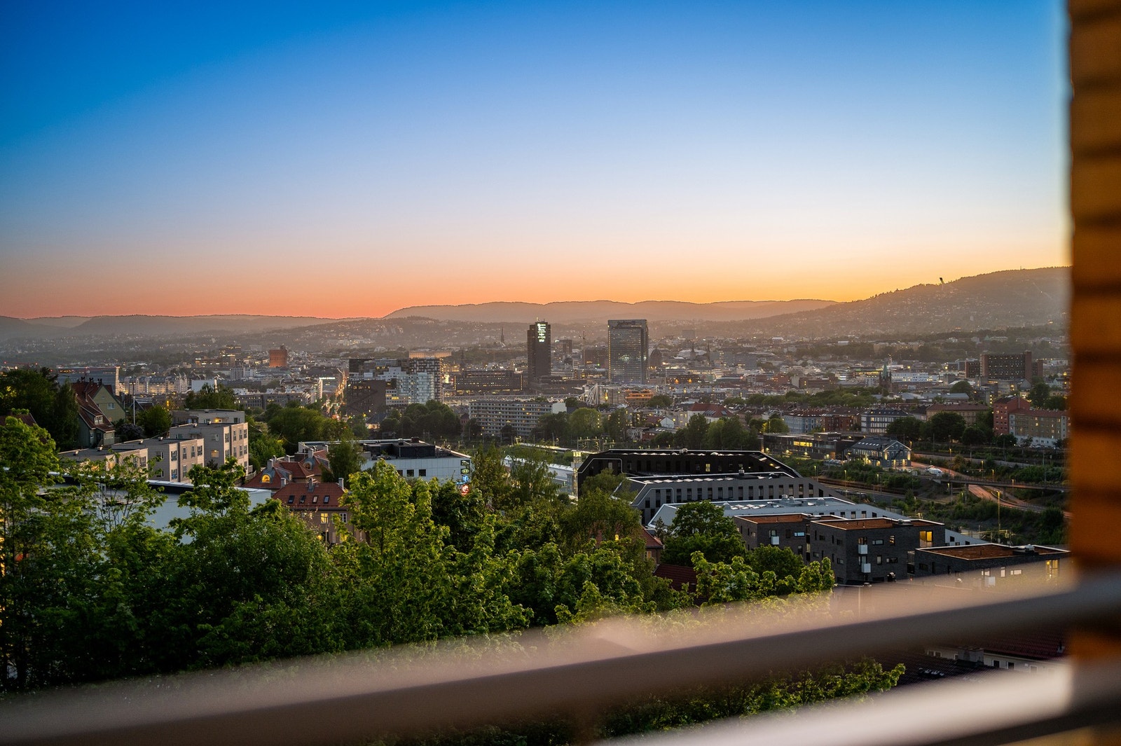 Nydelig utsikt over byen og solnedgangen som skaper en vakker himmel - perfekt for sene sommerkvelder. Galleribilde