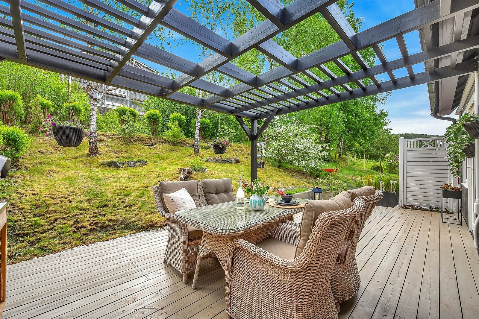 På baksiden av huset er det gressplen og beplantning. Galleribilde