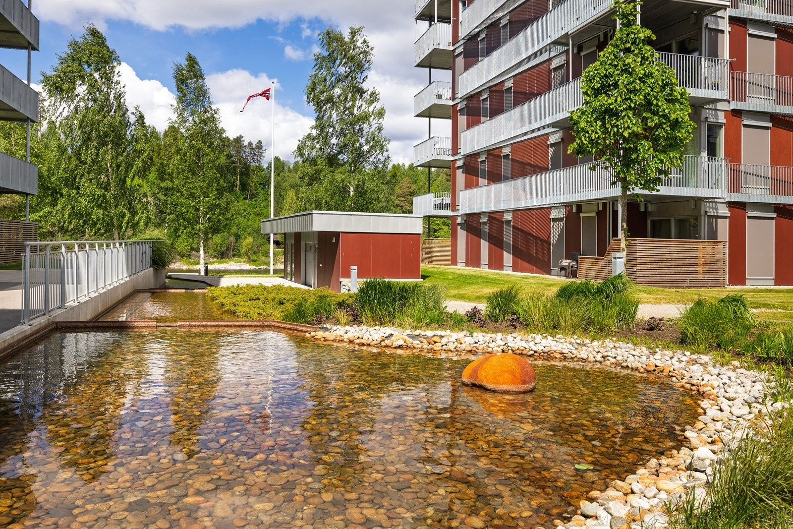 Parkmessige fellesområde med fine fasiliteter som vannspeil, lekeplass, "badehus" med muligheter for blant annet å låne kano Galleribilde