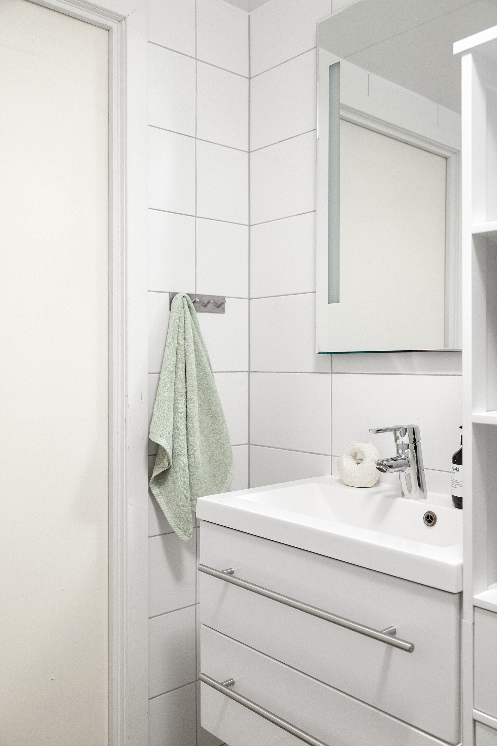 Speilskap med integrert belysning på vegg over servant. Dusjhjørne med regnfallsdusj og toalett. Galleribilde