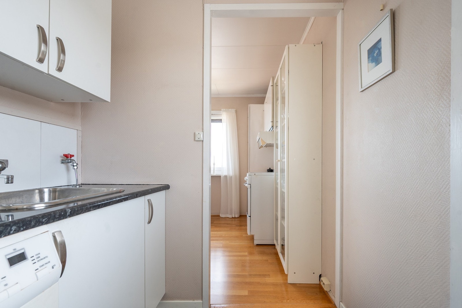 Rommet har skapinnredning, vask og opplegg for vaskemaskin. Galleribilde