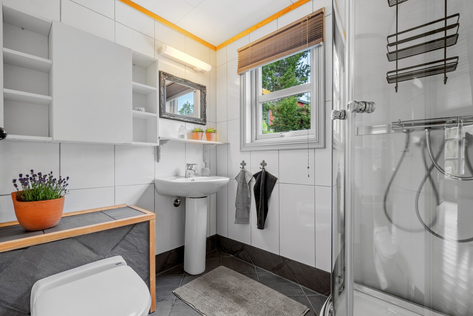 Hytta har et flislagt dusjrom med dusjkabinett og vakuumtoalett. Galleribilde