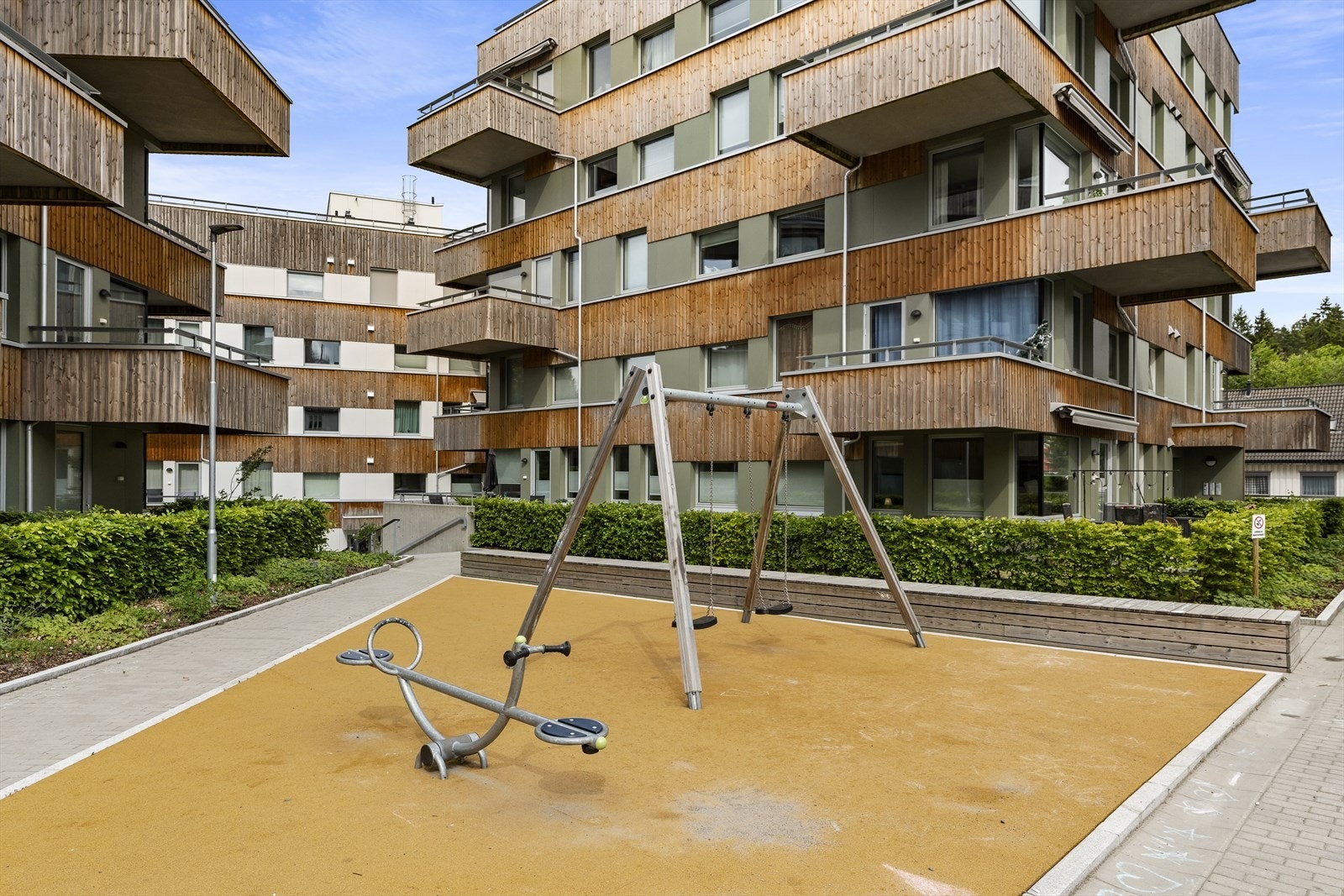 Fellesarealer er pent opparbeidet med gressplen, beplantning, lekeapparater, benker og sykkelparkering. Galleribilde