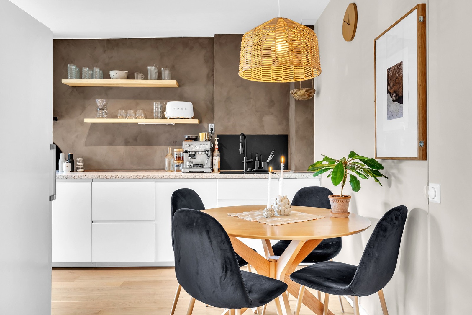 Kjøkkenet har et stilrent uttrykk med glatte fronter og terrazzo-inspirert benkeplate. Åpne hyller gir lett tilgjengelig oppbevaring og et personlig preg på rommet. Galleribilde