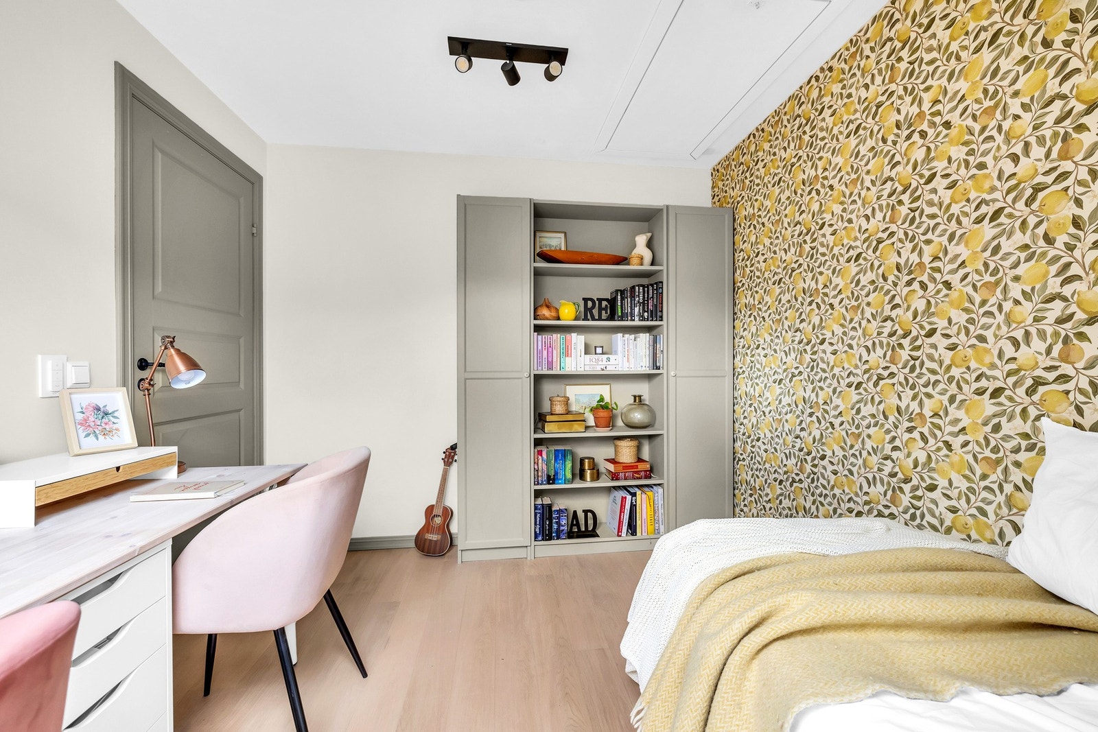 Tapet i varme toner gir rommet særpreg og en lun stemning. Plassbygd bokhylle og garderobeskap sørger for god oppbevaring. Galleribilde