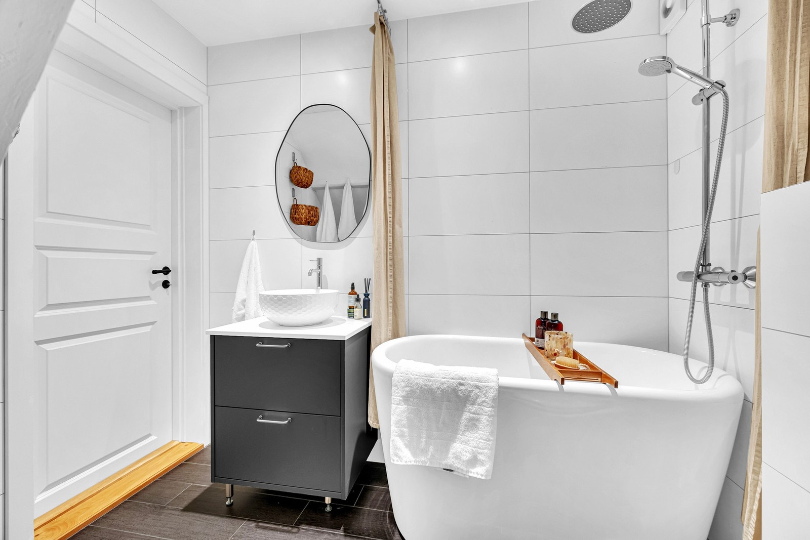 Badet fra 2017 har flislagte overflater, servant på innredning og frittstående badekar med dusjløsning. Enkel og stilren innredning gir rommet et moderne preg. Galleribilde