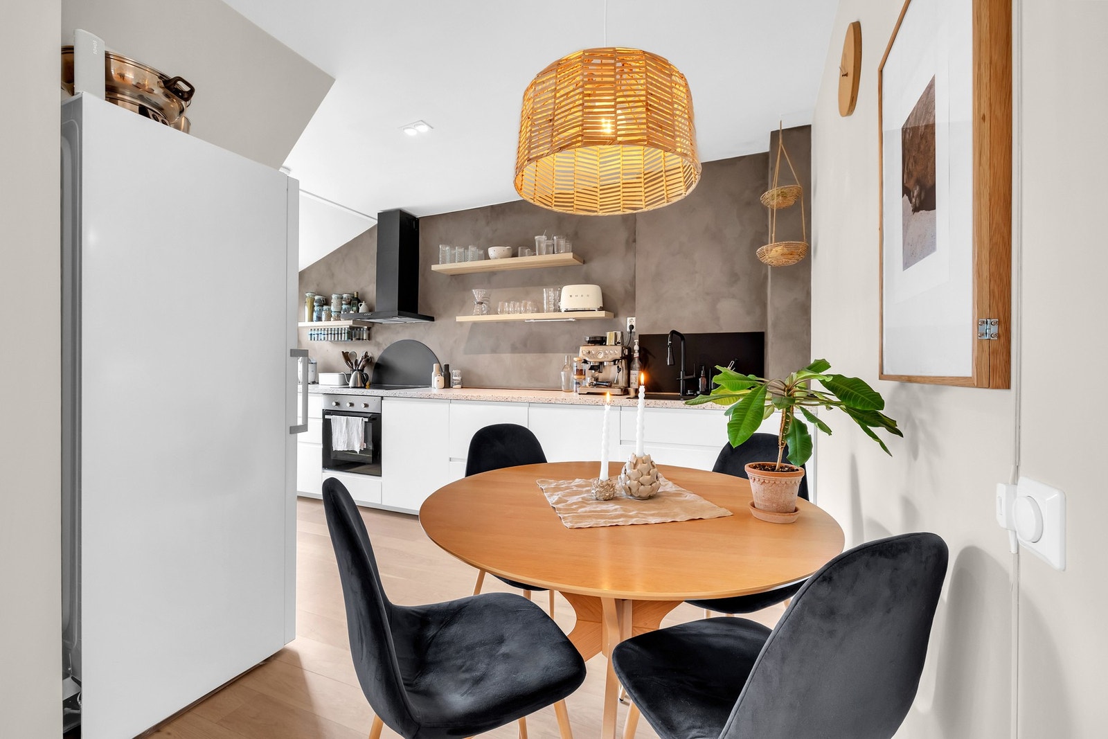 Spiseplassen er lunt plassert med nærhet til både kjøkken og oppholdsrom. Vegghengt kjøkken fra 2017 med åpne hyller og integrerte hvitevarer gir et luftig uttrykk. Galleribilde