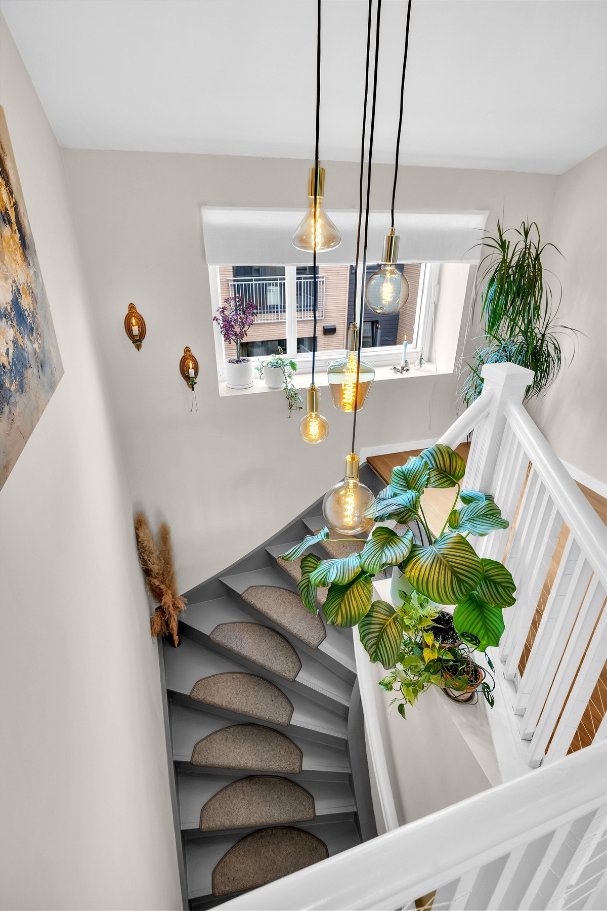 Trappeoppgangen har et lekkert lysinnslipp og innrammes av en moderne lampeinstallasjon. Gjennomgående fargevalg binder etasjene sammen på en fin måte. Galleribilde