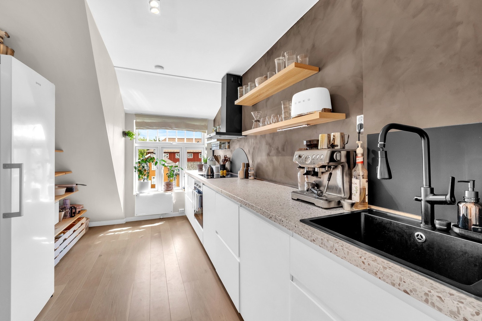 Kjøkkenet er effektivt utnyttet med lang benkeflate og godt med skapplass. Vindusflaten i enden av rommet gir et lyst arbeidsmiljø og hyggelig utsyn. Galleribilde