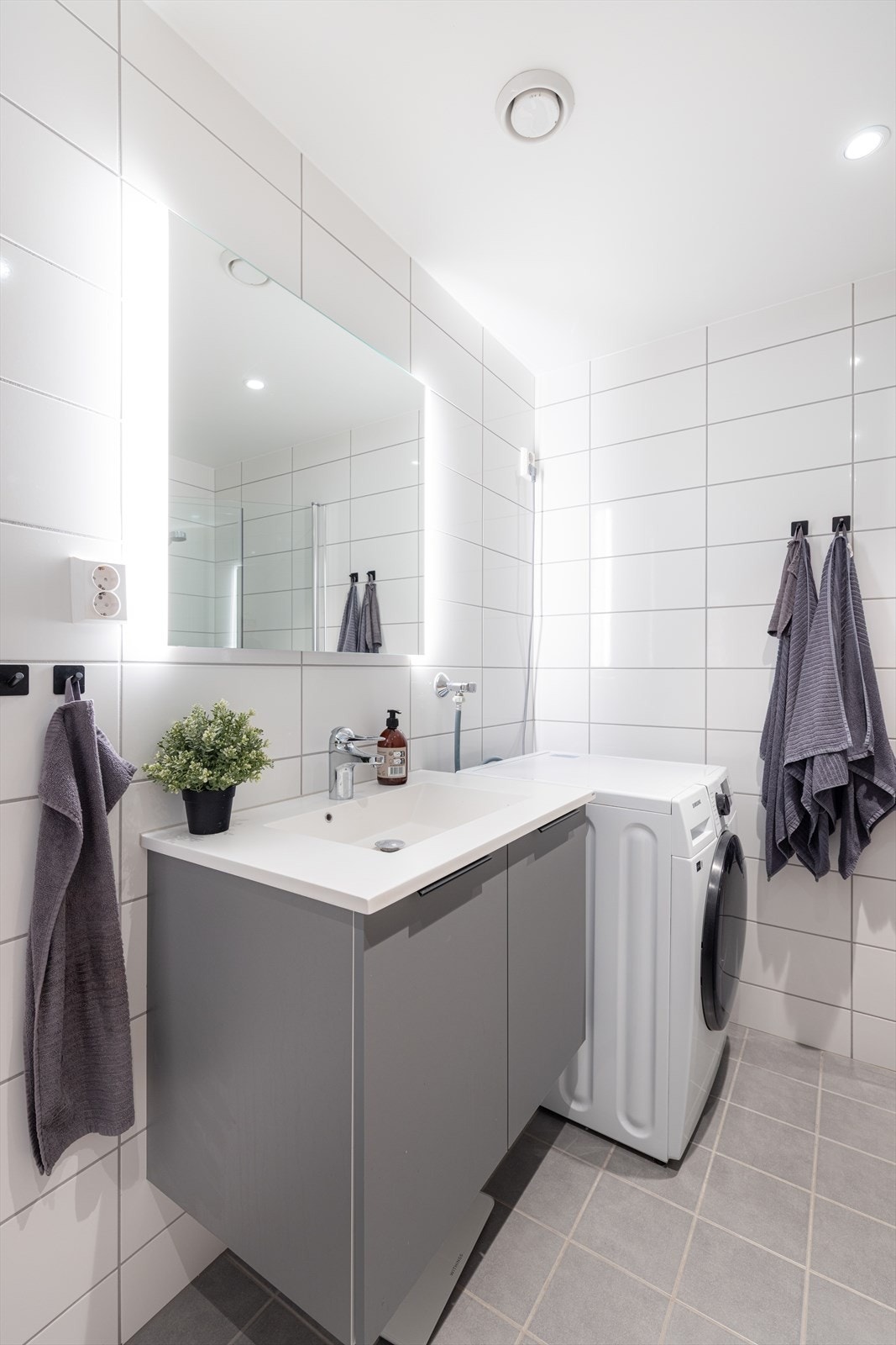 Badet er også innredet med veggmontert toalett, samt opplegg for og plass til vaskemaskin. Down-light belysning i tak. Galleribilde