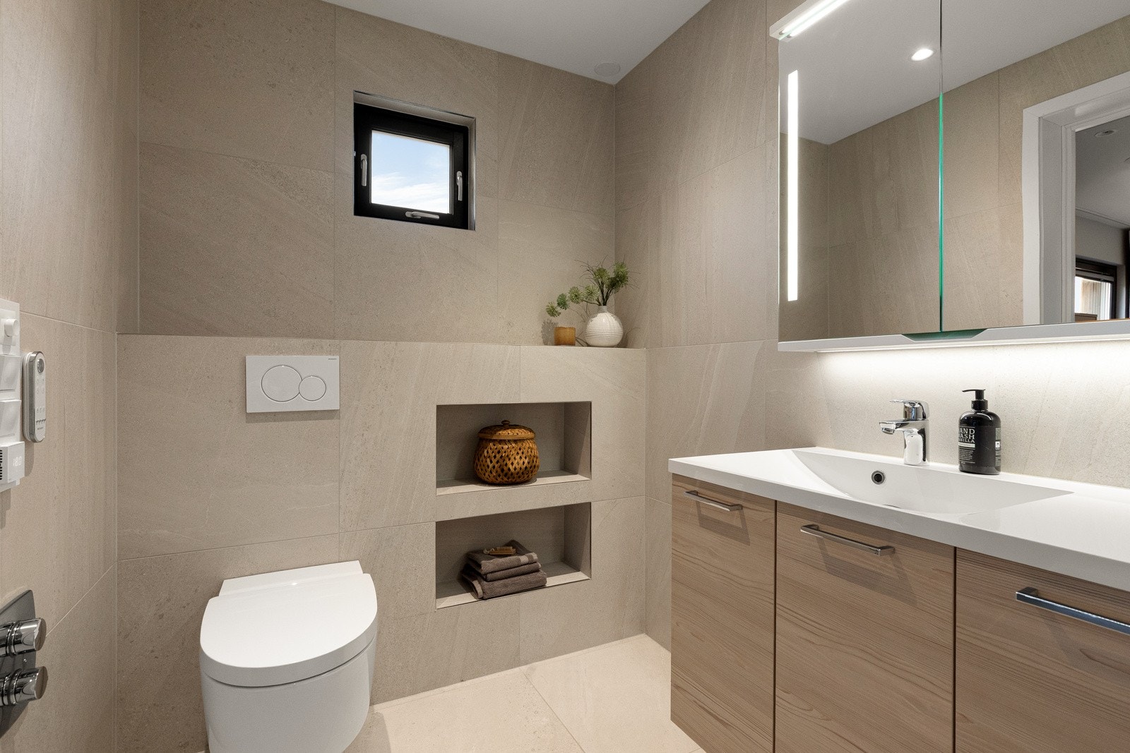 Downlights i taket og integrerte Sonos høyttalere gir både god belysning og flott lyd. Badet har listefri overgang mellom vegg og tak, og det er opplegg for dimbar belysning i hjørnet av himlingen ved ytterveggen. Galleribilde